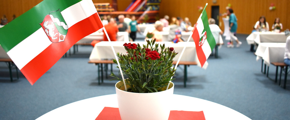 Eine Vase mit Blumen und 2 NRW-Flaggen